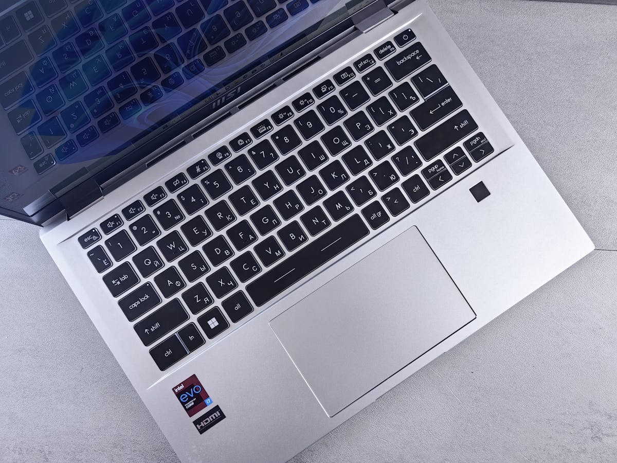 A laptop with a keyboard and a mouse on top