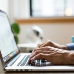 person typing on silver MacBook